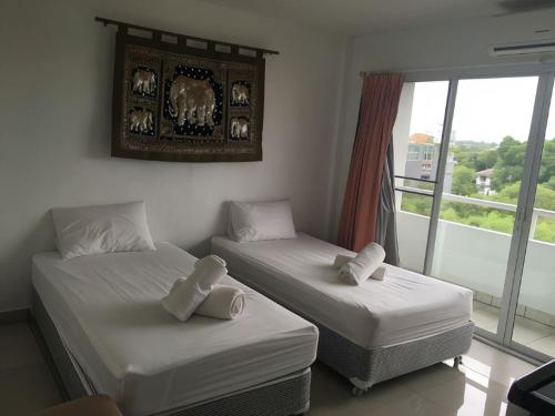 two beds in a room with a window at Jomtien Hostel in Jomtien Beach