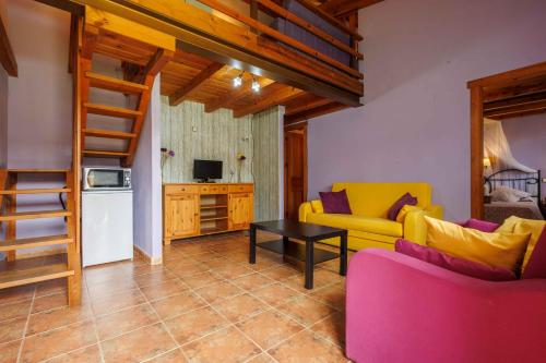 a living room with a yellow couch and a table at La Cerca Entre Hoces-10-20pax-Amplios espacios comunes in Sebúlcor