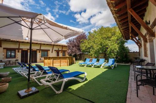 a group of chairs and an umbrella on a lawn at La Cerca Entre Hoces-10-20pax-Amplios espacios comunes in Sebúlcor