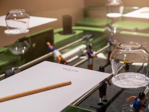 a toy table with a pen and glasses and a paper at Mercure Paris Centre Tour Eiffel in Paris