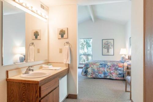 une salle de bain avec un lavabo et une chambre avec un lit dans l'établissement Wapato Point Resort, à Manson