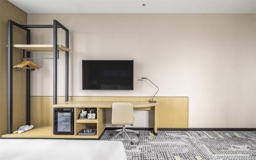 a room with a desk with a television and a chair at Hyatt Place New Taipei City Xinzhuang in Xinzhuang