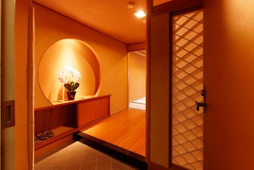 a bathroom with a mirror and a vase of flowers at 熱海の隠れ里 in Atami