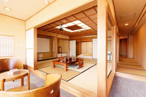 a living room with a table and a room with a bed at 熱海の隠れ里 in Atami
