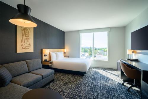 a hotel room with a bed and a couch at Hyatt Place Whitehorse in Whitehorse