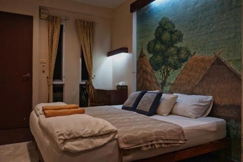a bedroom with a bed with pillows and a painting on the wall at ComeOn Stay&Sleep in Chiang Rai