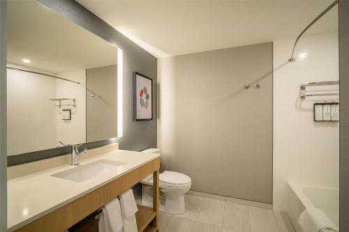 a bathroom with a sink and a toilet and a mirror at Hyatt Place Whitehorse in Whitehorse