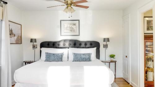 a bedroom with a white bed with a ceiling fan at Whitney by AvantStay Private Berkshires Estate in Sheffield