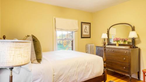 a bedroom with a bed and a dresser and a mirror at Whitney by AvantStay Private Berkshires Estate in Sheffield