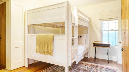 a white bunk bed in a room with a desk at Whitney by AvantStay Private Berkshires Estate in Sheffield