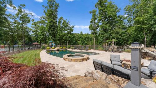 a swimming pool with a fire pit in a yard at Paradise Pointe by AvantStay Lakefront Views Playset in Lake Norman of Catawba