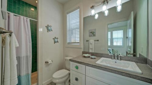 un bagno con lavandino, WC e specchio di A Crazy Beach by AvantStay Steps to Old Town a Port Aransas