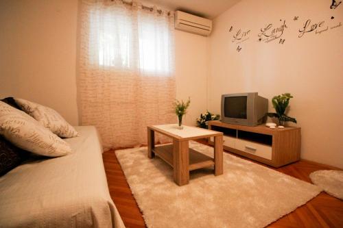 a living room with a couch and a tv and a table at Apartment Gabrijela in Split