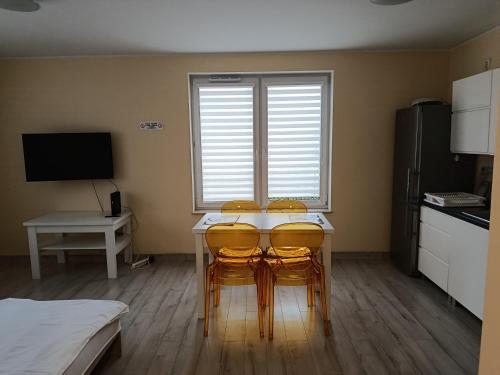a kitchen with a table and four chairs in a room at Apartament Rodzinny in Oława