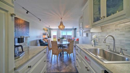 a kitchen with a sink and a table with chairs at Sleeps 18 2 Beachfront Condos w 2 Pools TennisPickleball Beach Boardwalk in Port Aransas