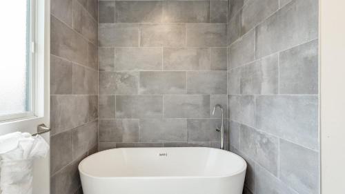 ein Badezimmer mit Toilette und gefliester Wand in der Unterkunft Velvet Sand I by AvantStay Steps to Newport Beach Private Rooftop w Outdoor Kitchen Hot Tub in Newport Beach