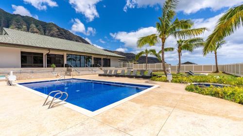a swimming pool in front of a house at Makaha Villa by AvantStay Mountain Ocean Views in Waianae