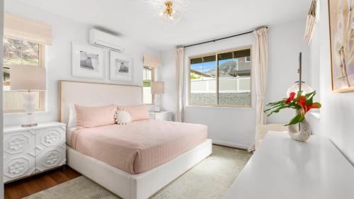 a white bedroom with a bed and a window at Makaha Villa by AvantStay Mountain Ocean Views in Waianae