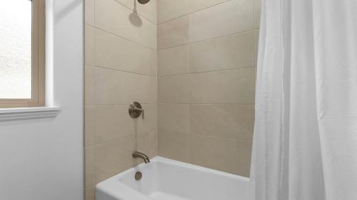 a shower with a white tub and a shower curtain at Makaha Villa by AvantStay Mountain Ocean Views in Waianae