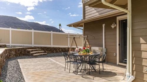 a patio with a table and chairs on the side of a house at Makaha Villa by AvantStay Mountain Ocean Views in Waianae