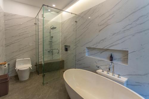 a bathroom with a tub and a shower and a toilet at Sepa Island Resort in Pulau Tondan Barat