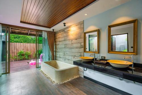 a bathroom with two sinks and a tub at Malabar Pool Villa Phuket in Phuket Town