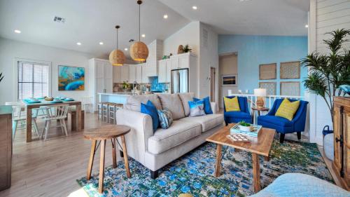 a living room and kitchen with a couch and a table at Free Heated Pool Golf Cart Zone Sea La Vie by AvantStay in Port Aransas