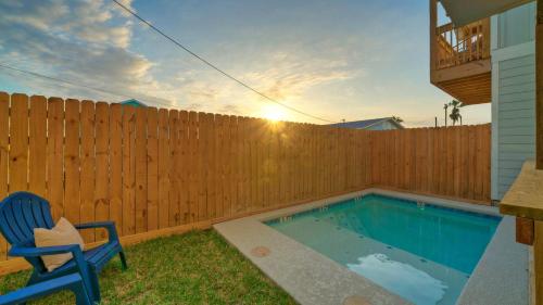 a backyard with a swimming pool and a wooden fence at Free Heated Pool Golf Cart Zone Sea La Vie by AvantStay in Port Aransas