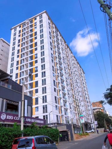 a large white building on the side of a street at Comfort Cove - One bedroom Apartment in Kilimani, Nairobi in Nairobi