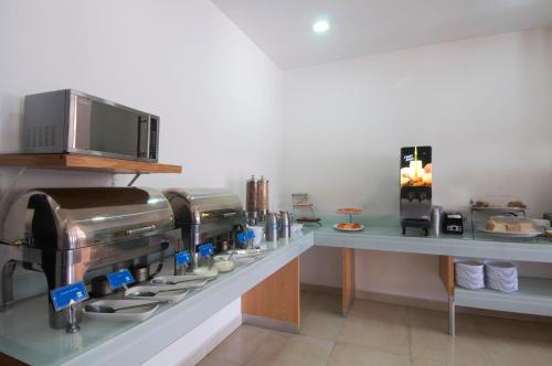a kitchen with a coffee machine on a counter at One Puebla FINSA in Puebla