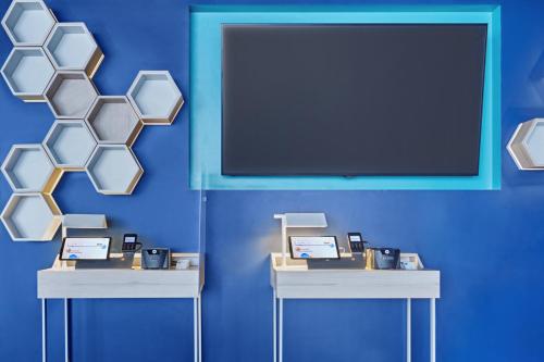 a blue wall with two tables with products on them at One Puebla FINSA in Puebla