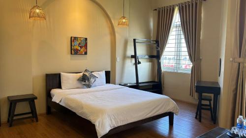 a bedroom with a bed and a window at Lá Hotel in Quang Ngai