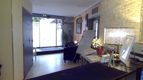 a living room with a table and a living room with a couch at Hotel De La Bastide in Carcassonne
