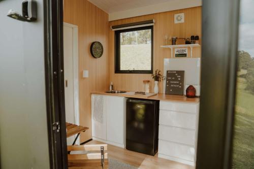 a kitchen with a stove and a counter top at Three-Kalm & Four-Sol by Tiny Away in Tallwoods Village