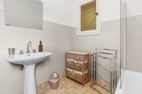 un bagno bianco con lavandino e doccia di Aux Portes Des Gorges Du Verdon a Peyroules