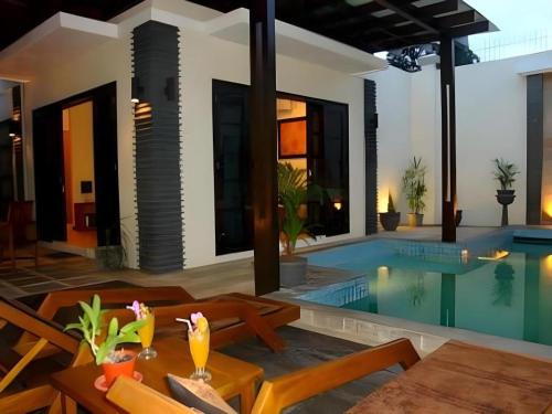a villa with a swimming pool and a house at The Luxio Hotel in Sorong