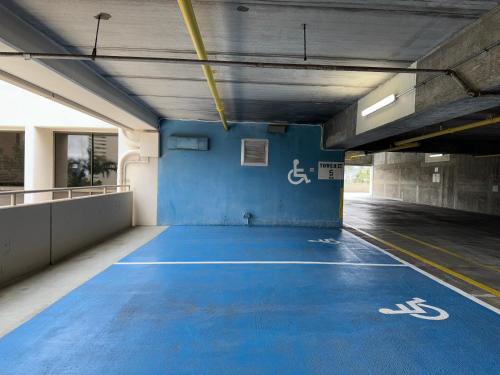 an empty parking garage with a blue painted basketball court at Mountain View Condo Near Beach with Free Parking! in Honolulu
