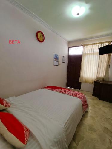 a bedroom with a bed with a clock on the wall at Vafa Guesthouse in Cianjur