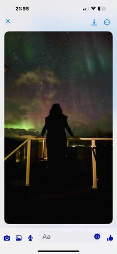 a person standing on a bridge looking at a night sky at Håkøyveien 151, Tromsø in Tromsø