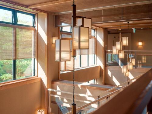 a hallway with stairs and windows in a building at Tabist Chikuba Shinyotei Hakodate Yunokawaonsen in Hakodate