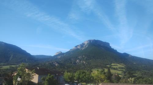 Blick auf eine Bergkette mit Bäumen und Häusern in der Unterkunft Auberge les rastels in Savournon