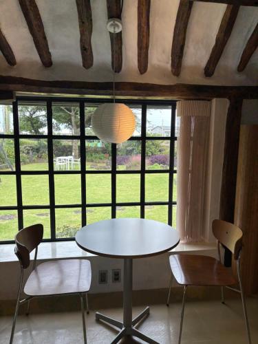 a table and chairs in a room with a window at Imjingotaek Hanok Stay Jeju Traditional House LP Cozy House, Wagon stay at Imjingotaek in Jeju