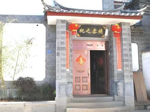 a building with a pink door with a sign on it at Lijiang Peach Hostel in Lijiang