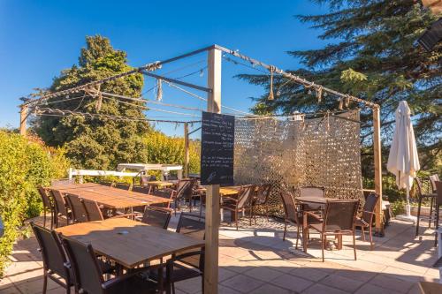 a patio with tables and chairs and a fence at La Bohême in Grimaud