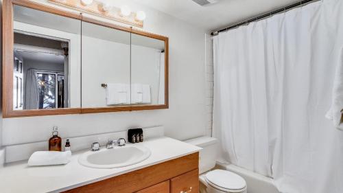 a white bathroom with a sink and a mirror at Marillac by AvantStay Gorgeous Ski Cabin w Balcony Patio in Olympic Valley
