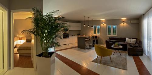 a living room with a couch and a table with a plant at Apartman Roza in Rogoznica