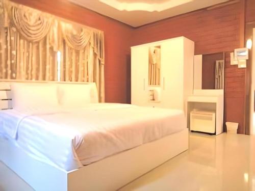 a large white bed in a bedroom with red walls at Lomdao Resort in Udon Thani