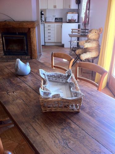 une corbeille assise sur une table en bois avec un ours en peluche dans l'établissement L'Ombrière, à Saint-Thomas-de-Cônac
