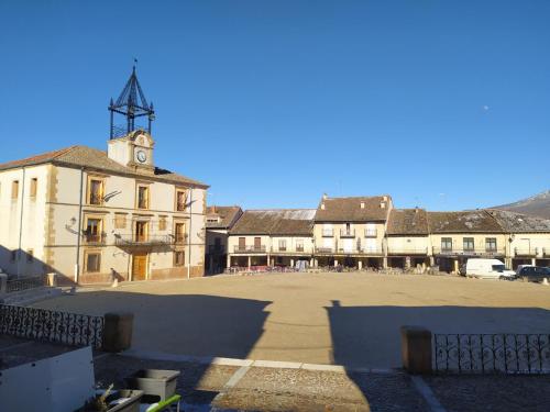 a large building with a clock tower in a courtyard at La Cerca Entre Hoces-10-20pax-Amplios espacios comunes in Sebúlcor