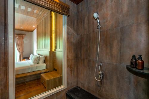 a bathroom with a shower and a bed in a room at Malabar Pool Villa Phuket in Phuket Town